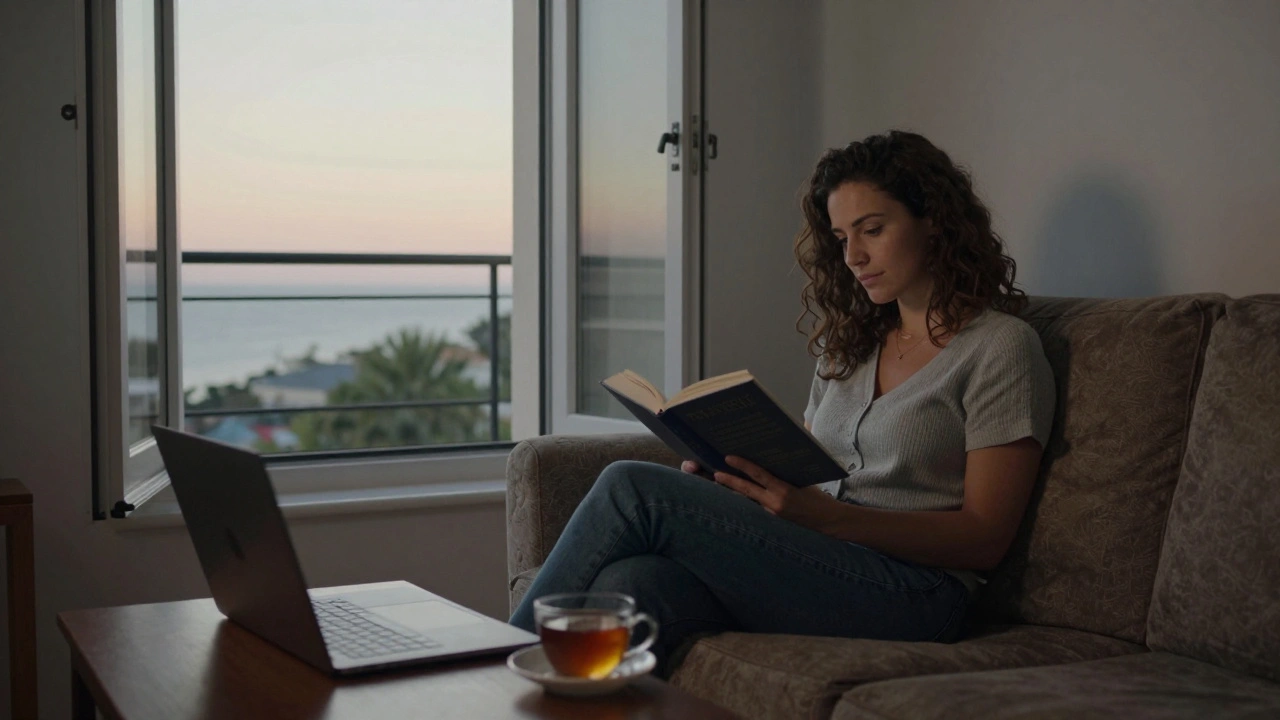 Bir kadın, Akdeniz manzaralı bir pencereden gelen güneşte kitap okuyor.